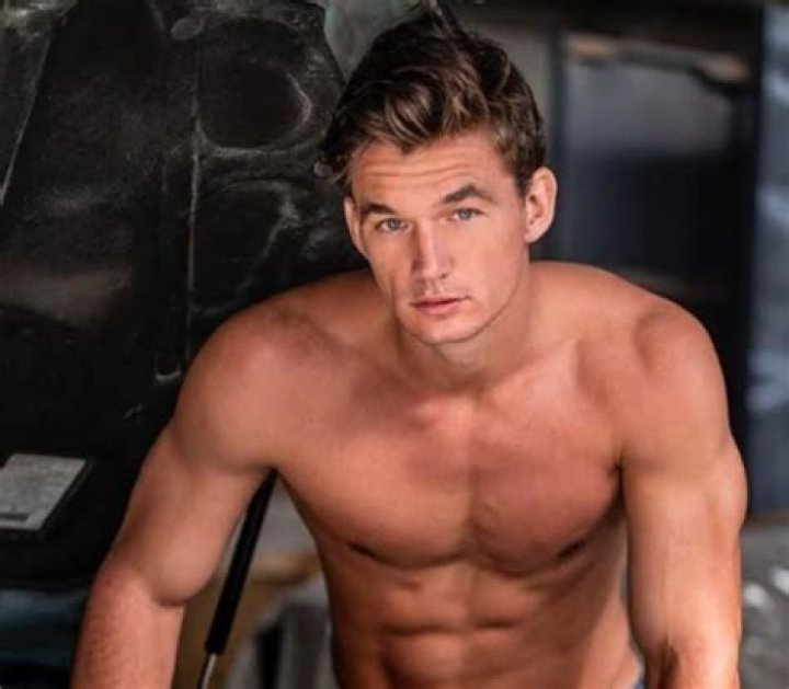 Tyler Cameron stands in front of a body of water